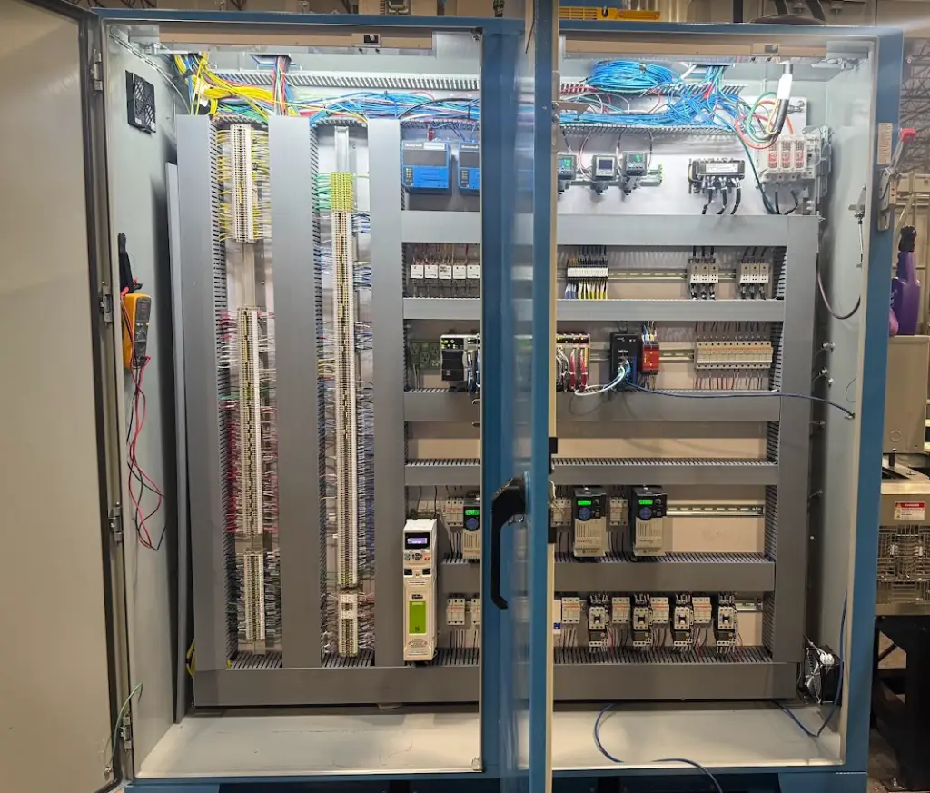 Electrical control panel with PLCs, drives, relays, and industrial wiring for a Precision Conveyor finishing system