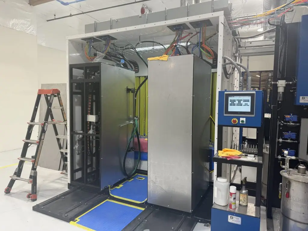 Explosion-proof automated spray gun positioners with servo-driven rotation assemblies installed on a production paint system.