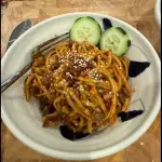 Peanut butter chilli beef noodles with ground beef, flat noodles, chili oil, and sliced cucumber