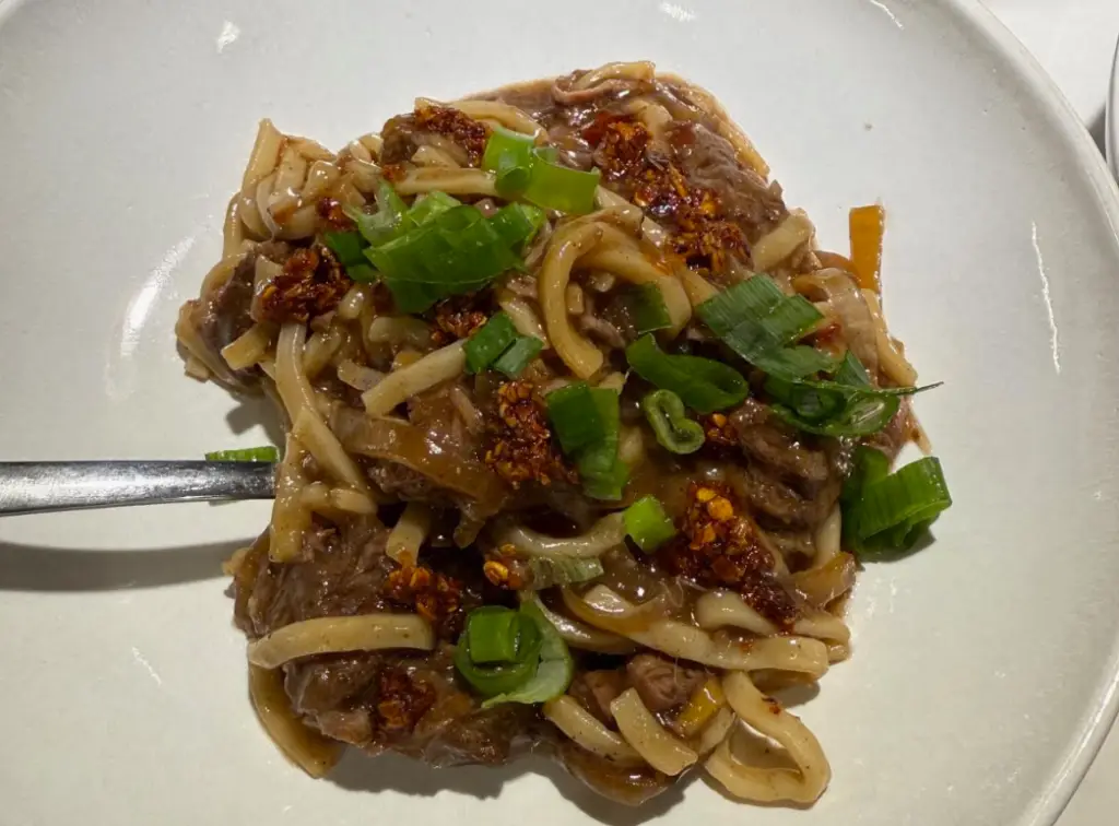 Spicy crockpot Mongolian beef and noodles with onions and green onions